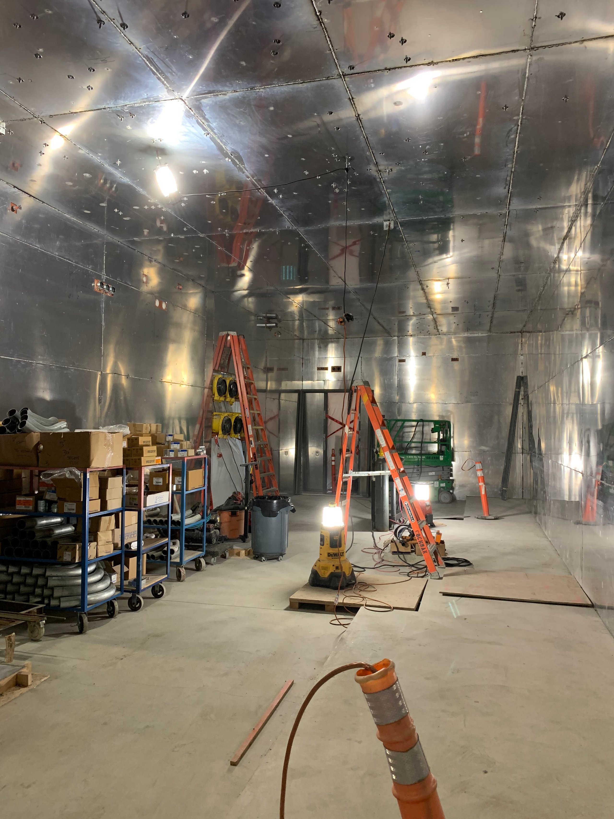 Industrial interior with metal walls, ladders, shelves, and construction equipment